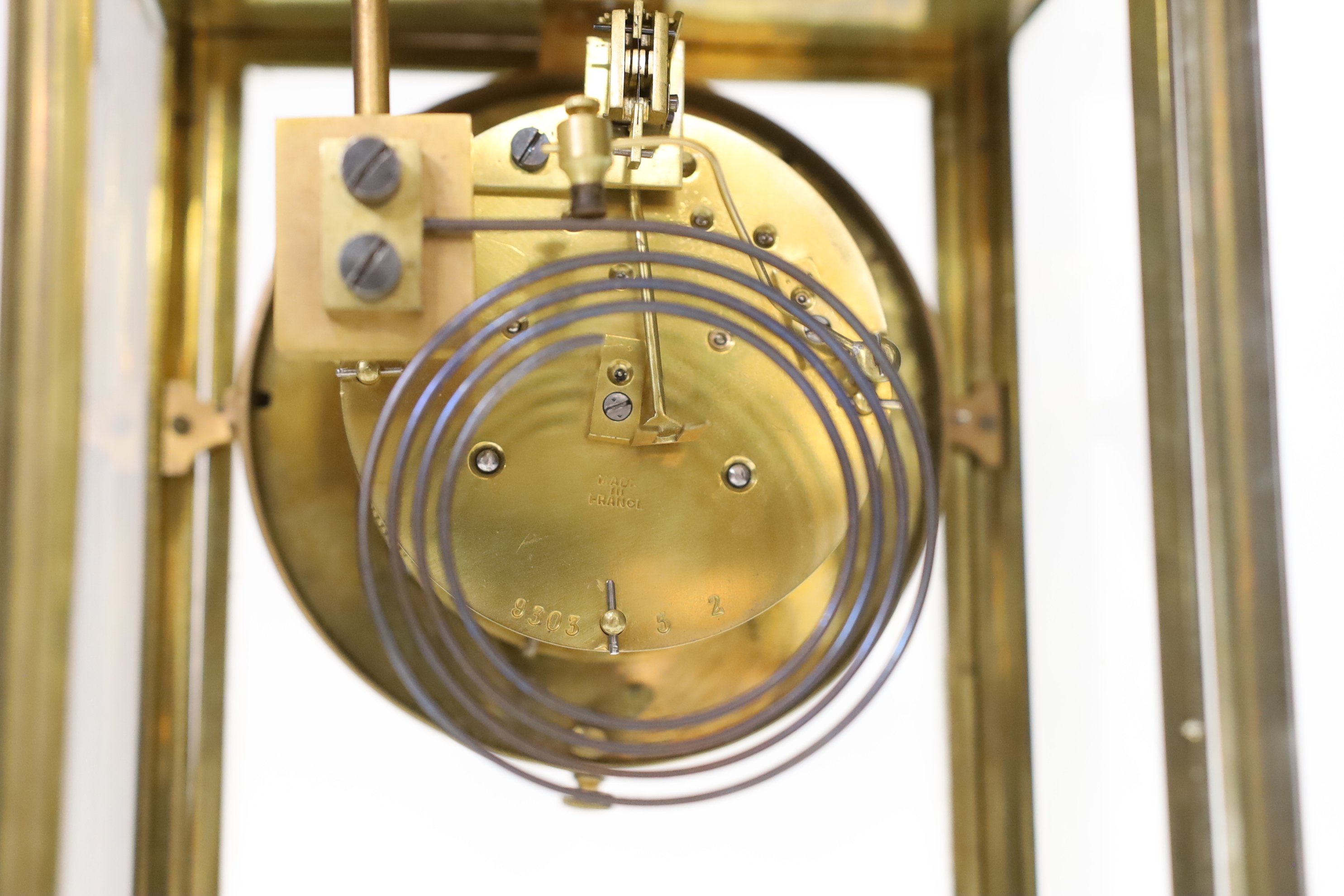 An early 20th century brass four glass clock with mercury pendulum, 28cm high